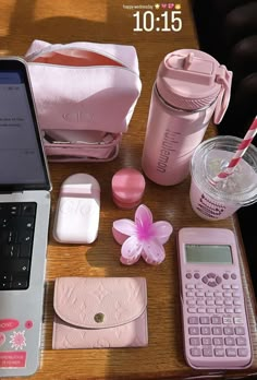 a laptop computer sitting on top of a wooden table next to other items and accessories