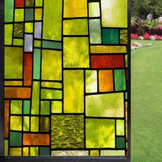 a large stained glass window sitting on top of a lush green field