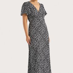 A romantic midi dress with a V-neckline and subtle ruching across the bust. Featuring soft, slightly flared sleeves and a floating skirt that crops above the ankles, it is designed in a vintage-inspired black and white floral motif. Back waist ties are offered for a custom fit. Pare back with simple accessories for lon Black Feminine V-neck Midi Dress, Elegant Maxi Floral Dress With Ditsy Print, Elegant Flowy V-neck Dress With Floral Print, Elegant Ditsy Floral Print Maxi Dress, Chic Dresses With Ditsy Floral Print And Flutter Sleeves, Elegant V-neck Midi Dress With Ditsy Floral Print, Elegant Flowy Maxi Dress With Ditsy Floral Print, Garden Party V-neck Midi Dress With Gathered Sleeves, Flowy Floral Print Midi Dress With Empire Waist