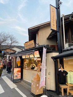 people are walking down the street in front of shops