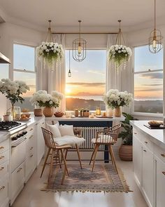 a kitchen filled with lots of white furniture and flowers in vases on the windowsill