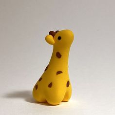 a yellow toy giraffe with brown spots on it's face