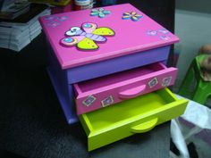 a child's toy chest sitting on top of a table next to other toys