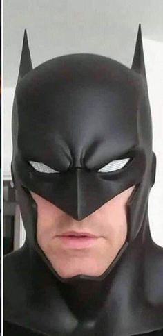 the man is wearing a batman mask and looking at the camera with an angry look on his face