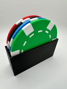 four pieces of plastic sitting on top of a black holder with red, white and blue strips sticking out of it