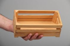 a person holding a wooden box in their hand