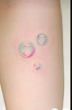 two soap bubbles on the side of a woman's leg