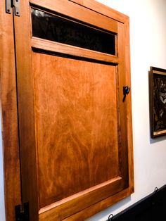 a wooden door with two paintings on the wall