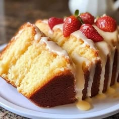 a piece of cake with icing and strawberries on top sitting on a plate