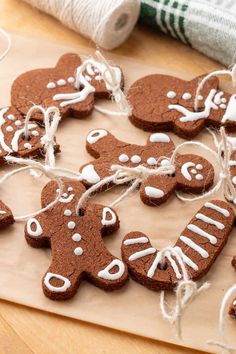 gingerbread cut out with white icing on a cutting board next to twine of twine