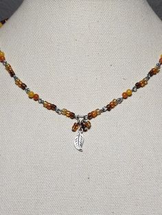 Metal leaf charm with brown, orange & yellow glass accent beads Fall Necklaces Beaded, Fall Seed Bead Necklace, Autumn Seed Bead Necklace, Emerald Pumpkin Beads Necklace, Pumpkin Beads Necklace, Autum Leaf Necklace, Autumn Necklace, Metal Leaves, Leaf Charms