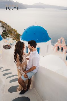 a man and woman standing next to each other near the ocean