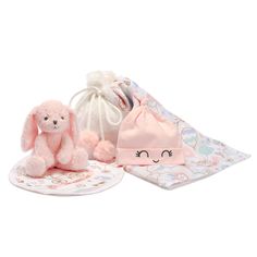 a pink stuffed animal sitting on top of a white plate next to a small bag