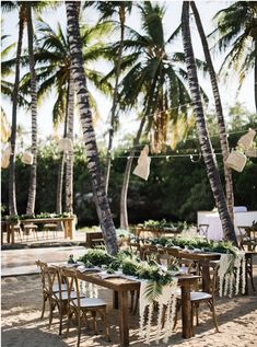 tables and chairs set up under palm trees