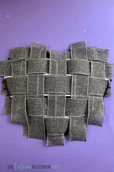 a piece of fabric that has been cut into squares and placed on a purple surface