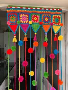 a colorful curtain with tassels and pom poms hanging from it's sides