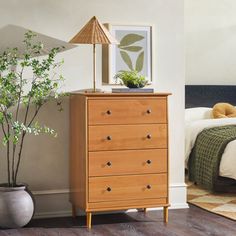 a bedroom scene with focus on the chest of drawers and a bed in the background