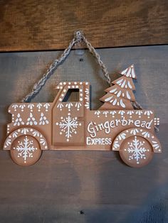 a wooden sign that says gingerbread express with snowflakes on the truck and trees