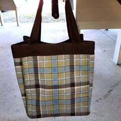 a brown and blue plaid bag sitting on top of a table