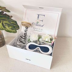 a white box with sunglasses and flowers in it