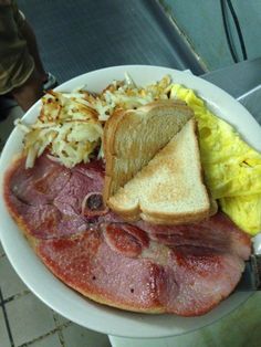 a white plate topped with ham, toast and hash browns