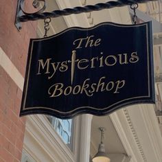 the mysterious bookshop sign is hanging from the side of a building