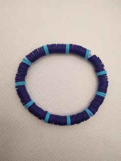 a blue and white beaded bracelet sitting on top of a table