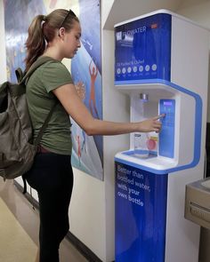 a woman standing next to a water dispenser