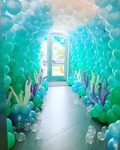 an entrance to a room decorated with balloons and seaweed, under which is a door