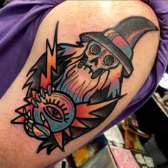 a man with a wizard hat and eyeball tattoo on his arm