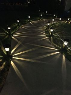 a path with many lit up lanterns on each side and grass in the back ground