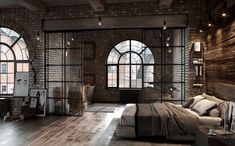 an industrial bedroom with brick walls and arched windows