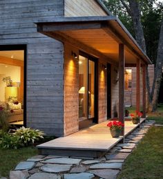 a house that is made out of wood and has stone steps leading up to the front door