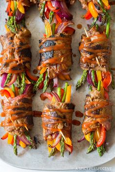 skewered steaks with vegetables and sauce on a platter ready to be served