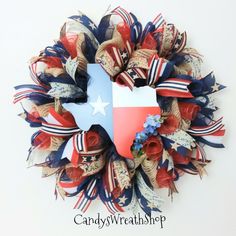 a wreath with the state of texas painted on it and red, white, and blue flowers