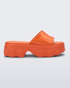 Side view of a orange Ella Slide platform Modern Platform Jelly Sandals In Synthetic Material, Modern Platform Jelly Sandals In Synthetic, Modern Platform Jelly Sandals, Modern Synthetic Platform Jelly Sandals, Trendy Jelly Sandals With Rubber Sole For Summer, Modern Platform Jelly Sandals With Round Toe, Trendy Summer Jelly Sandals With Rubber Sole, Modern Open Toe Jelly Sandals, Trendy Chunky Platform Sport Sandals For The Beach