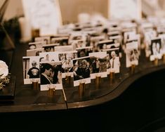 an arrangement of photos and flowers on a table at a wedding reception with place cards