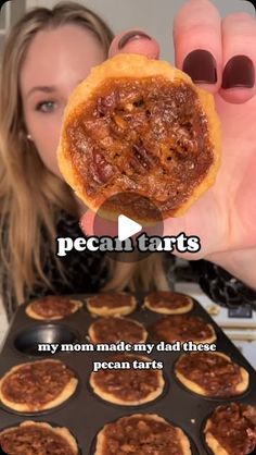 a woman holding up a piece of food in front of her face with the words pecan tarts on it