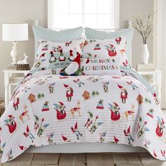 a white bed with christmas themed comforter and pillows