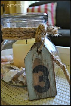 a candle is sitting on a table with a tag hanging from it's side