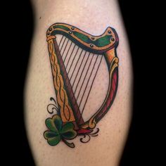 a tattoo with a harp and shamrocks on it