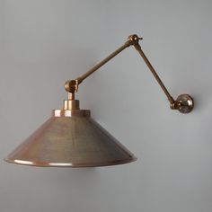 an antique brass wall light on a white wall