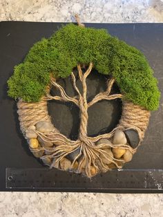 a tree is made out of jute and rocks on top of a black board