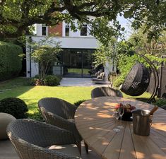 a table and chairs on a patio in front of a house with an outside dining area