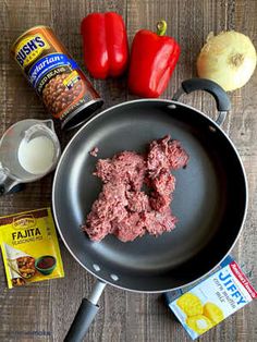 ingredients to make an appetizer laid out on a wooden table including peppers, onions and seasonings