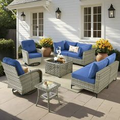 an outdoor patio with wicker furniture and blue cushions