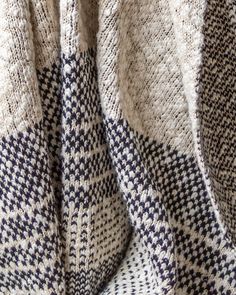 a close up of a blanket on a bed with blue and white checkered fabric