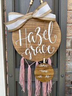 a wooden sign that says hazel grace hangs on the front door with tassels