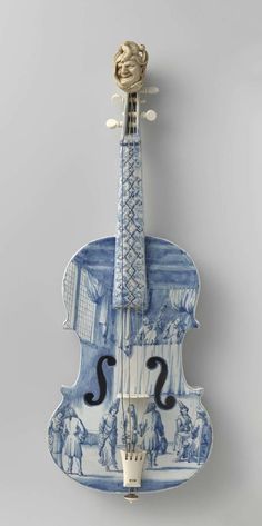 a blue and white violin hanging from the side with an image of people on it