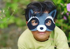 a young boy wearing a mask with a raccoon on it